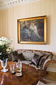 Oil painting above Biedermeier sofa, white roses in glass goblet and aperitif on table in foreground
