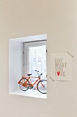 Model bicycle in window niche and motto stuck to wall with washi tape