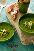 Green vegetable soup and slices of bread topped with ham