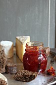 A jar of chilli and apple jam, bread and cheese
