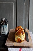 Spicy brioche on a chopping board with a knife
