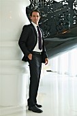 Junger Geschäftsmann mit Anzug steht in eleganter Halle