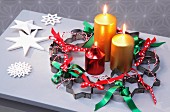 Weihnachtlicher Kranz aus Plätzchenausstechern und Schleifenbändern und drei Kerzen