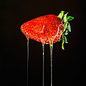 A strawberry dripping with honey (close-up)