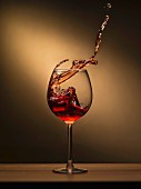 Rotwein spritzt aus dem Glas