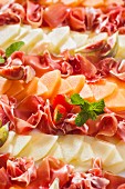 A party platter of melon, ham and figs