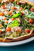 Pizza with salmon, spinach and tomato