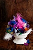 Easter arrangement of colourful feathers in bowl