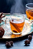 Cider punch with star anise and cinnamon stick in a tea cup