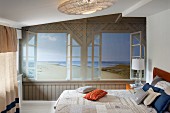 Trompe-l'œil beach mural on wall of bedroom with double bed