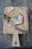 Seeded bread topped with homemade liver sausage on a wooden board