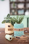A roll of twine decorated with a bunch of fresh herbs and sticky tape