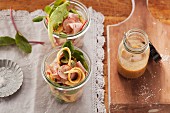 Leberkäse (beef and pork meatloaf) salad with omelette strips and fresh radishes served in jars