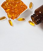 Fish oil capsules in a dish and a bottle