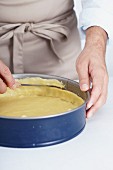 Shortcrust pastry being placed in a spring form tin