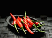 Fresh red chilli peppers on a black plate