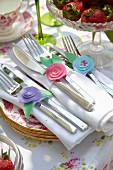 Hand-crafted napkin rings made from romantic, pastel felt flowers on festive garden table