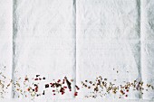 Various spices on the edge of a picture on a white cloth