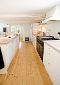 Kitchen counter with white base units and free-standing counter in kitchen with wooden floor
