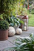 Ornamental spheres and lanterns on paved area in garden in front of bamboo bush