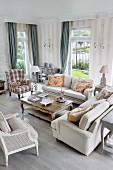 Pale, country-house-style sofas and armchairs in elegant interior with grey patterned wallpaper
