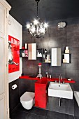 Vintage bathroom with charcoal tiles, red storage cabinet, film poster and chandelier