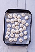 Mini meringues on a baking tray (seen from above)