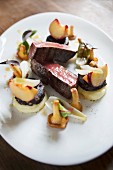 Rare saddle of venison with long pepper, vineyard peaches and fresh chanterelle mushrooms, pine black pudding at the restaurant 'Le Bambou' in Freiberg