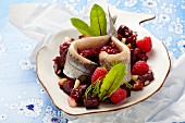 Soused herring on a beetroot salad with raspberries and nuts