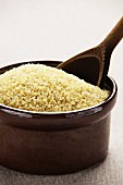 Bulgur wheat in a ceramic bowl with a wooden spoon