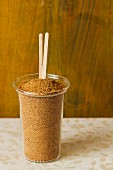 Coconut flower sugar in a glass with wooden sticks