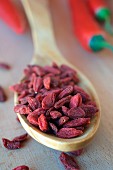 Dried goji berries on a wooden spoon