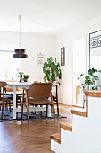 White table and brown chairs below pendant lamps in dining room