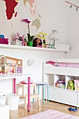 White loft bed with shelves below, toys on shelf and dolls' house on table in girl's bedroom