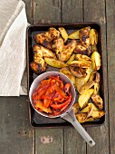 Grilled chicken wings with potato wedges and peppers