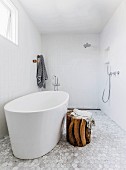 Accessible shower area, free-standing bathtub and rustic wooden stool in designer bathroom