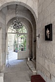 House entrance with stone archway and double doors leading to courtyard