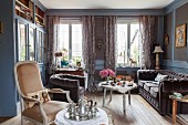 Blue-grey fitted cupboards with glass door panels and upholstered furnishings in lounge