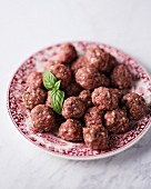 A plate of raw mini beef meatballs