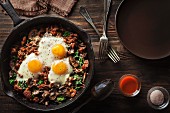 Fried mushrooms with spinach, sausage and fried eggs (seen from above)