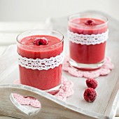 Raspberry and banana smoothies on a wooden tray