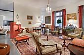 Interior filled with antique seating and side tables with mixture of patterns on Oriental rugs and traditional upholstery fabrics