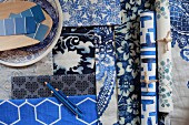 Wallpapers and fabrics in blue and white patterns and paint sample strips