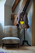Leopard-print easy chair next to clothes on tailors' dummy in corner