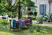 Set garden table, wicker and metal chairs, vintage candle lanterns and candlesticks