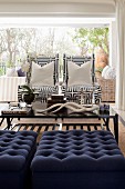 Seating area with blue ottomans and armchairs with geometric-patterned covers