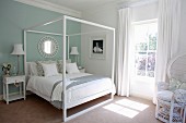 Modern four-poster bed in white and pastel turquoise bedroom