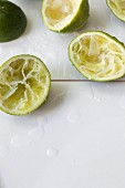 Squeezed limes on white tiles