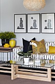 Sofa mit gestreiftem Bezug, Glastisch und gelbe Farbakzente durch Kissen und Vasen