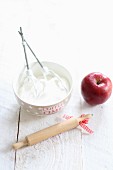 Beaten egg whites, a rolling pin and an apple